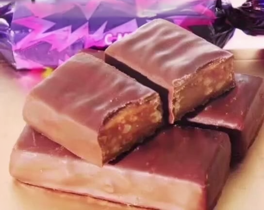 Chocolate-covered toffee croquant candy bars with caramel nut filling, a typical product of a vacuum toffee cooker line